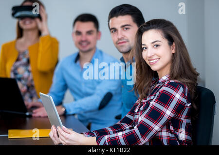 Team di persone motivate, utilizzando vari dispositivi ad una fusione di avvio. concetto, il lavoro di squadra Foto Stock