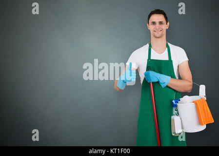 Bidello maschio azienda attrezzature di pulizia Foto Stock