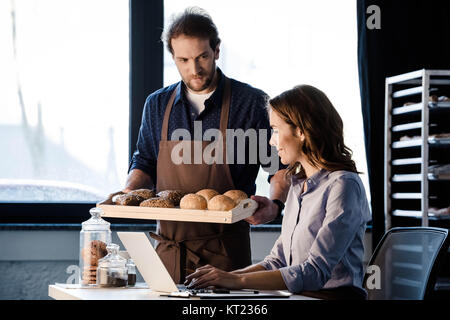 Fornai esaminando la pasticceria Foto Stock