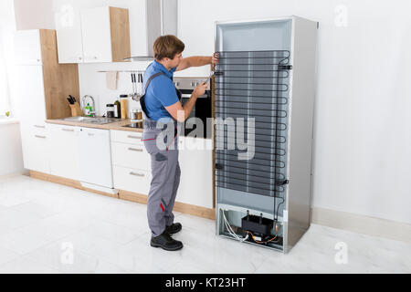 Veterani lavorando sul frigo con il cacciavite Foto Stock