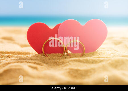 Due cuori con anelli sulla spiaggia Foto Stock