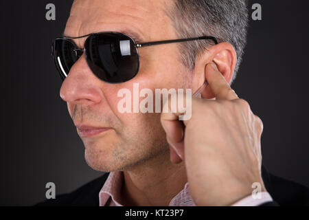 Maschio di guardia di sicurezza ascolto di auricolare Foto Stock