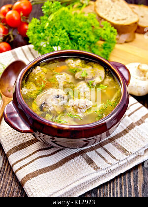 Zuppa con polpette di carne e funghi in ciotola marrone a bordo Foto Stock