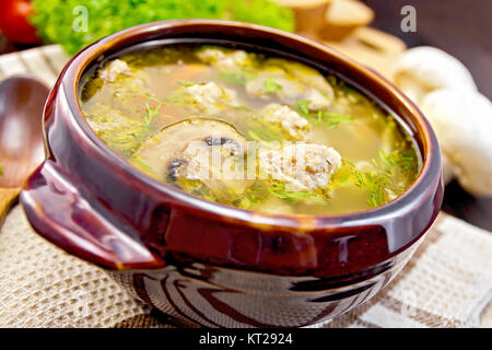 Zuppa con polpette di carne e funghi in vaso di creta a bordo Foto Stock