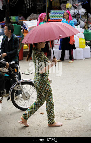 Giovane donna con un ombrello a Meo Vac mercato, Ha Giang Provincia del Vietnam del nord Foto Stock