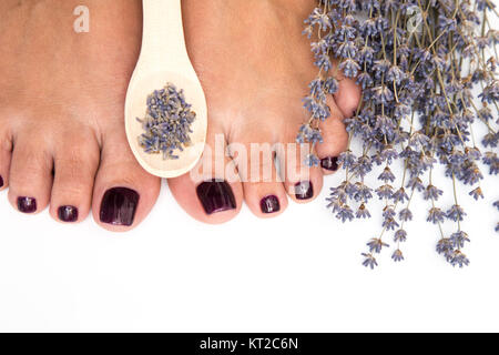 Primo piano di una femmina di piedi con pedicure sui chiodi e lavanda. a spa salone. Gambe concetto di cura Foto Stock