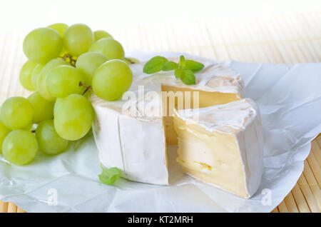 Il francese maturo Camembert formaggio a pasta morbida con uva e maggiorana Foto Stock