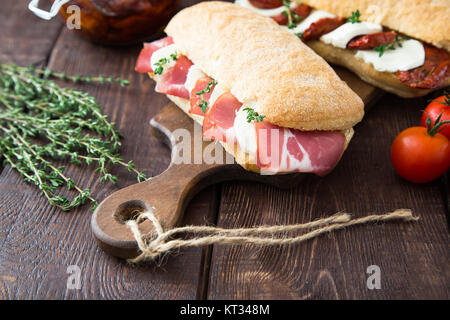 Panini assortiti. panino Caprese con mozzarella di bufala e pomodori secchi e ciabatta con prosciutto Foto Stock