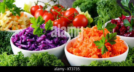 Composizione con quattro insalata di verdure ciotole sul tavolo di legno Foto Stock