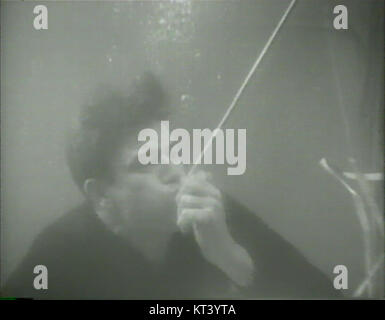 Una rara fotografia che mostra il leggendario attore John Wayne in una scena subacquea. Questa immagine cattura l'attore in un ambiente inaspettato, mostrando la sua versatilità oltre i suoi famosi ruoli western. Foto Stock