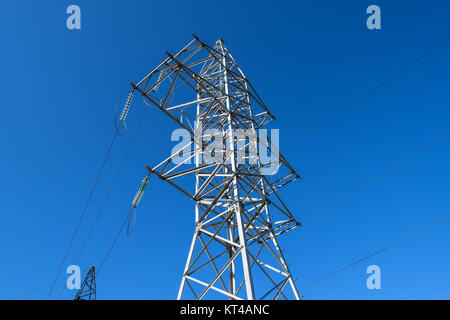 Supporta le linee elettriche ad alta tensione contro il cielo blu Foto Stock