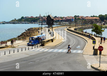 Strada costiera e il vecchio mulino a vento di legno sul ihtmus della antica città di Nesebar, Bulgaria Foto Stock