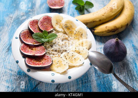 Sana colazione: fiocchi d'avena con fichi freschi, le banane e il latte di cocco e semi di Chia Foto Stock