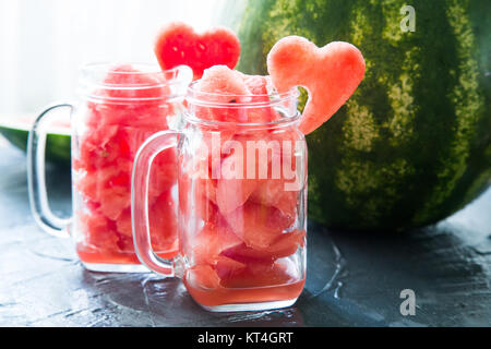 Anguria in vasetti di vetro decorate con fette di anguria curvo come simboli di cuore Foto Stock