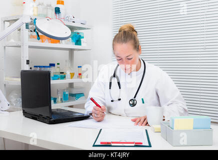 Medico esperto practitioned controlli delle registrazioni pazienti Foto Stock