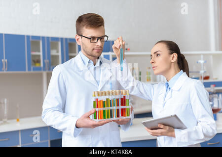 Professional di farmacisti in camici di ispezionare il tubo di prova con il reagente di laboratorio Foto Stock