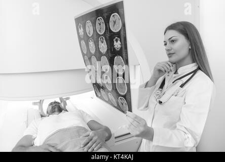Fiducioso medico piacevole lavorare con MRI dei risultati di scansione Foto Stock