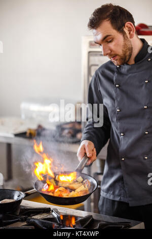 Lo chef è verdure di agitazione Foto Stock