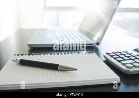 Office Workplace con penna, notebook, calcolatrice e computer portatile sul tavolo. Foto Stock