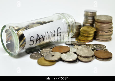 Etichetta di risparmio in un vasetto di vetro con monete fuoriuscita Foto Stock