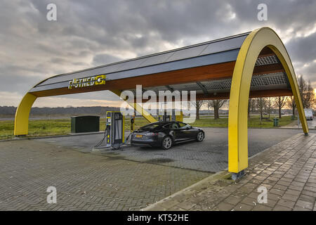 GRONINGEN, Paesi Bassi - 30 Novembre 2016: Tesla carica in auto alla stazione di carica veloce per i veicoli elettrici lungo l'autostrada Foto Stock