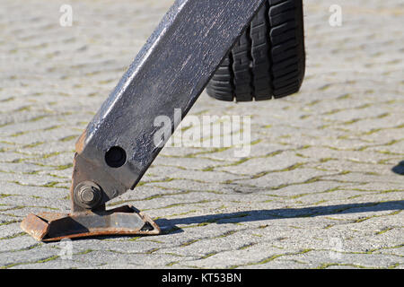 Carrello forte outrigger stabilizzare le gambe estese. Impianti di risalita del braccio materiale da costruzione macchine sul tetto del palazzo. Foto Stock