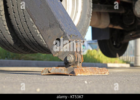 Carrello forte outrigger stabilizzare le gambe estese. Impianti di risalita del braccio materiale da costruzione macchine sul tetto del palazzo. Foto Stock