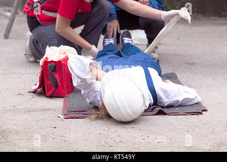 Primo soccorso dopo incidente sul posto di lavoro Foto Stock