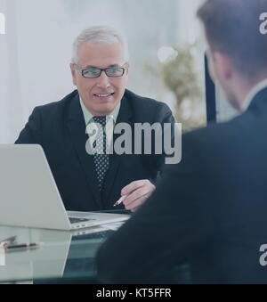 Business Partner per discutere in sala riunioni con il loro collega Foto Stock