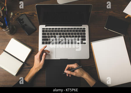 Vista superiore del designer utilizzando laptop e tablet grafica al lavoro Foto Stock