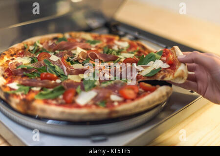 Vista parziale di donna prendendo pezzo di pizza italiana su vinile record giocatore Foto Stock