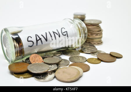 Etichetta di risparmio in un vasetto di vetro con monete fuoriuscita Foto Stock