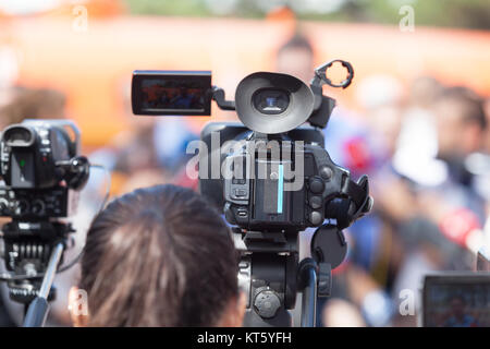 La ripresa di un evento con una videocamera. Premere il tasto Conferenza. Foto Stock