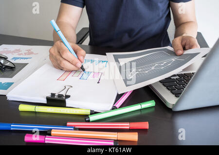 L'uomo la scrittura grafico su carta con penna a colori. Foto Stock
