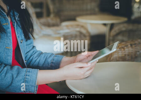 Close-up giovane donna utilizzando tablet con grafico finanziario schermo nel coffee shop. Foto Stock