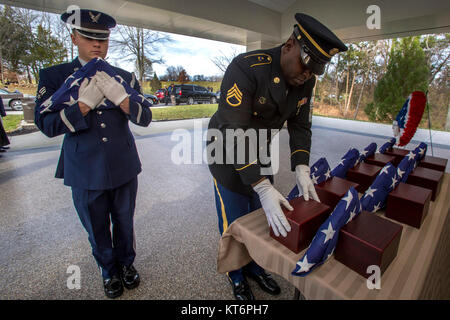 Stati Uniti Il personale dell'esercito Sgt. Asim Williams, destra posiziona un urna contenente l'cremains di un veterano mentre Senior Airman Joshua Kaemmer, entrambi membri del Brigadiere Generale William C. Doyle Memorial Cemetery Guardia d'onore, attende per posizionare una bandiera americana di fronte ad esso durante la ventiseiesima New Jersey missione di onore cerimonia presso il Cimitero di North Hanover Township, N.J., nov. 30, 2017. Il cremains di una guerra mondiale - veterano John J. Aron, sette II Guerra Mondiale Veterani - Leslie H. Allen, Louis J. Bakelaar, Gilbert C. Johnson, Theodore Martin, Robert W. Milner, James K. Molony e Edith L. Sherwood, e Foto Stock