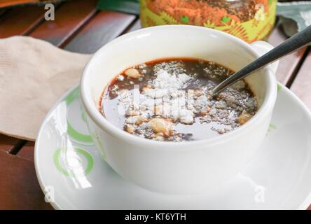 Creamer in cappuccino insolubile sul pavimento in legno sfondo Foto Stock