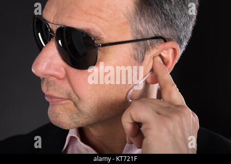 Maschio di guardia di sicurezza ascolto di auricolare Foto Stock