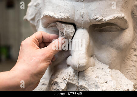 Positivo Negativo modulo. Le mani dello scultore e martello dettaglio mentre il carving. Foto Stock