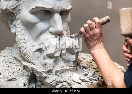 Positivo Negativo modulo. Le mani dello scultore e martello dettaglio mentre il carving. Foto Stock