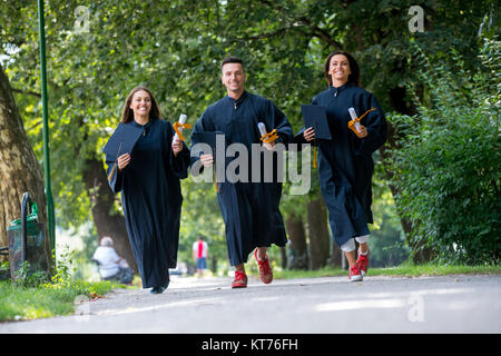 Istruzione, graduazione persone concetto - gruppo di felice gli studenti internazionali in mortaio e schede di corso di laurea gli abiti con diplomi Foto Stock