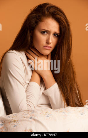 Malattia aviaria mal di gola donna in appoggio a letto Foto Stock