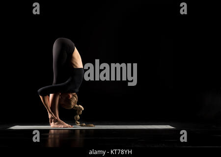 Donna in piedi in posizione di yoga Foto Stock