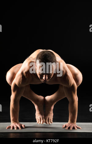 Uomo in piedi in posizione di yoga Foto Stock