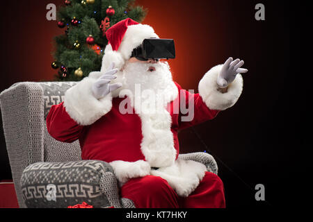 Babbo Natale che indossa la realtà virtuale auricolare Foto Stock