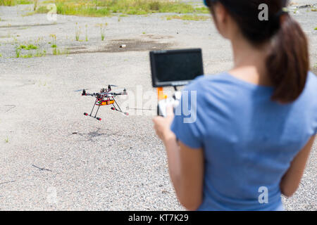 Donna con controllo drone Foto Stock