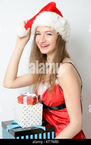 Giovani modello femminile, Natale sessione di foto. Venti anni ragazza di Santa Claus costume, azienda confezione regalo. Foto Stock