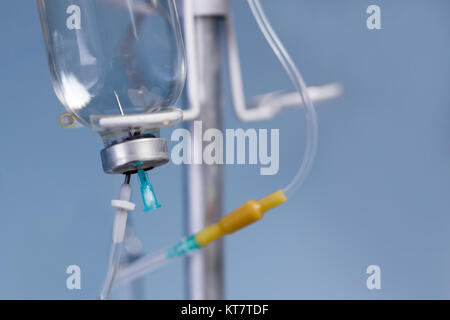 Soluzione salina medica flebo IV close up su fondo azzurro in ospedale. Foto Stock