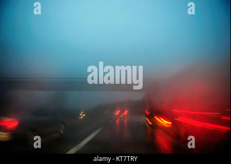 Sfocate luci auto su una autostrada durante il malinconico escursione notturna. Le luci rosse e blu cielo durante la serata drive Foto Stock