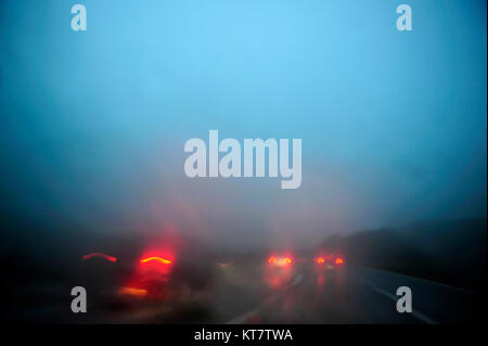 Sfocate luci auto su una autostrada durante il malinconico escursione notturna. Le luci rosse e blu cielo durante la serata drive Foto Stock